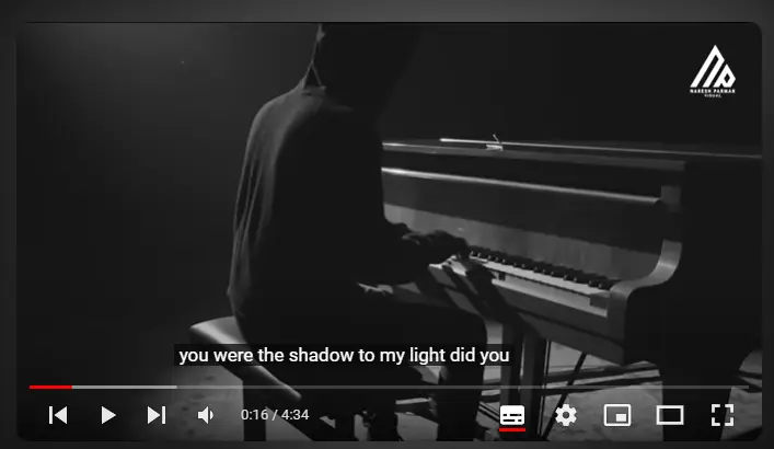 A pianist playing in a dimly lit room with subtitles displayed, illustrating the SEO benefits of video subtitles